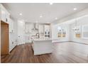 Modern kitchen with white cabinetry, stainless steel appliances, large center island, and open dining area at 1131 Joseph Pl, Erie, CO 80026
