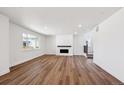Bright and airy living room boasts modern fireplace, hardwood floors, and large windows offering plenty of natural light at 1131 Joseph Pl, Erie, CO 80026