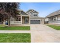 Charming two-story home with brick accents, gray garage door, well-kept lawn, and a welcoming front porch at 15378 E 99Th Way, Commerce City, CO 80022