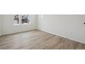 Bright bedroom featuring light wood floors and ample natural light from two windows at 8414 Vona Ln, Littleton, CO 80125