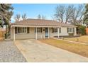 Inviting single-story home with a covered carport and cozy front yard at 956 Racine St, Aurora, CO 80011