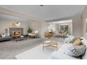 Open concept living room featuring a stone fireplace and large windows at 956 Racine St, Aurora, CO 80011