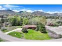 Charming home with lush landscaping, mountain views, and a long private drive at 6155 Meadowbrook Dr, Morrison, CO 80465