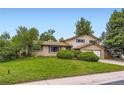 Traditional two-story home featuring a brick facade, attached two-car garage, and verdant front lawn at 1497 S Oakland St, Aurora, CO 80012