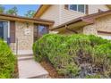 Inviting entryway with lush landscaping, brick accents, and a classic wood door at 1497 S Oakland St, Aurora, CO 80012