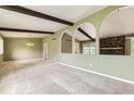 Spacious living room boasts stone fireplace, exposed beams, and arched room entrances at 1497 S Oakland St, Aurora, CO 80012
