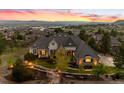 An impressive two-story home with a stone and stucco facade, tile roof, and a professionally landscaped front yard at sunset at 4541 Tierra Alta Dr, Castle Rock, CO 80104