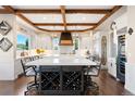 Bright, spacious kitchen featuring a large center island with wine rack, beamed ceilings, and modern appliances at 4541 Tierra Alta Dr, Castle Rock, CO 80104
