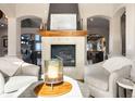 Cozy living room with a fireplace and views of the outdoors through large arched doorways at 4541 Tierra Alta Dr, Castle Rock, CO 80104