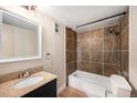 Updated bathroom with granite vanity, stylish tiling in the shower/tub combination, and vinyl floor at 381 S Ames St # F204, Lakewood, CO 80226