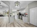 Bright, updated kitchen featuring stainless steel appliances, granite countertops, and a modern chandelier at 8307 S Garland Cir, Littleton, CO 80128