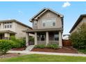 Attractive two-story home featuring a welcoming front porch and manicured landscaping at 5716 Boston Ct, Denver, CO 80238