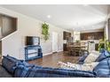 Open concept living room with hardwood floors, oversized sofa, and view of the kitchen at 12835 Randles Ave, Parker, CO 80134
