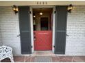 Close up of a red dutch door with decorative sconces and a view into the home's foyer at 3225 S Race St, Englewood, CO 80113