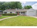 Inviting single-story home featuring a red front door, well-kept lawn, and an attached one car garage at 3225 S Race St, Englewood, CO 80113