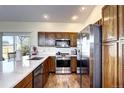 Kitchen featuring stainless steel appliances, dark wood cabinets, and marble countertops at 3983 Cambridge Ave, Broomfield, CO 80020