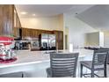 Bright open kitchen with stainless appliances, marble countertops, and bar stool seating at 3983 Cambridge Ave, Broomfield, CO 80020