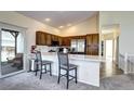 Open kitchen with stainless steel appliances, marble countertops, barstool seating, and a sliding glass door at 3983 Cambridge Ave, Broomfield, CO 80020