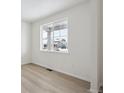 Bright spare bedroom with neutral walls, hardwood floors and a large window at 692 Apex Rise St, Erie, CO 80516