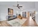 Open-concept living room featuring wood floors, a ceiling fan, and a comfortable seating arrangement at 270 N Holcomb Cir, Castle Rock, CO 80104