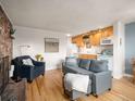 Inviting living space featuring a gray sofa, hardwood floors, and a view of the adjacent kitchen area at 155 S Pennsylvania St # 310, Denver, CO 80209