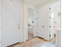Hallway featuring an open bedroom and bathroom with white doors and neutral decor throughout at 21 N Edge Cliff St, Castle Rock, CO 80104