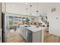Modern kitchen with stainless steel appliances, a large island, and an adjacent dining area, with a living room in the background at 21 N Edge Cliff St, Castle Rock, CO 80104