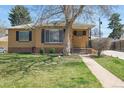 Well-maintained front yard with a brick house and manicured landscaping at 2562 S Xavier St, Denver, CO 80219