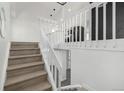 View of the staircase with wood stairs and white railings, leading to a lower level at 17486 E Plateau Dr, Aurora, CO 80015