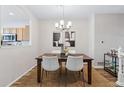 Dining room featuring a wooden table, white chairs, and modern lighting at 9733 E Carolina Pl, Aurora, CO 80247