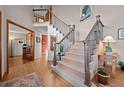 Welcoming entryway with wood floors, an elegant staircase, and natural light at 2042 Chesapeake Pl, Highlands Ranch, CO 80126
