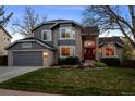 Charming gray home with brick accents, a two-car garage, and a landscaped front yard at 2042 Chesapeake Pl, Highlands Ranch, CO 80126