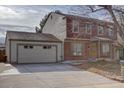 Two-story home with attached garage and large driveway at 1455 S Vaughn Cir, Aurora, CO 80012