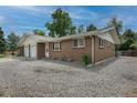 Single-story brick home featuring an attached garage and gravel front yard at 9320 W 48Th Ave, Wheat Ridge, CO 80033