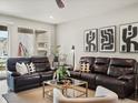 Comfortable living room features plush leather sofas, stylish decor, and ample natural light at 5205 Periwinkle Way, Brighton, CO 80640