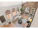 Inviting living room with a brick fireplace, built-in bookshelves, and large windows at 9117 Buck Hill Dr, Highlands Ranch, CO 80126