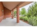 Inviting front porch with brick columns, wood siding and views of the lush landscaping at 5420 Crestone Cir, Boulder, CO 80301