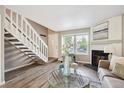 A staircase leads up in this living room featuring a fireplace and neutral decor at 3078 W 107Th Pl # D, Westminster, CO 80031