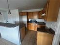 Spacious kitchen featuring wooden cabinets, laminate counters, a microwave, and tile flooring at 2005 W 86Th Ave, Denver, CO 80260