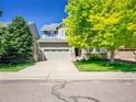 Inviting two-story home with lush greenery and a spacious driveway, under a clear blue sky at 6525 S Abilene St, Englewood, CO 80111