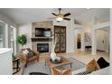 Cozy living room with stone fireplace, ceiling fan and hardwood floors at 2840 Canyon Crest Ln, Highlands Ranch, CO 80126