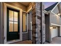 Inviting entryway with a stylish front door, stone pillar, and modern exterior lighting at 11412 Autumn Moon St, Littleton, CO 80125