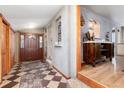 The foyer features a tiled floor, decorative niches, and an adjacent wood cabinet at 23136 Kiowa Rd, Indian Hills, CO 80454