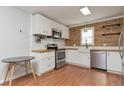 Modern kitchen with white cabinets, butcher block countertops, stainless steel appliances, and wood plank accent wall at 5700 W 28Th Ave # 6, Wheat Ridge, CO 80214