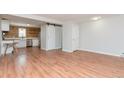 Bright living room with wood-look flooring, and a view of the kitchen featuring a rustic wood plank wall at 5700 W 28Th Ave # 6, Wheat Ridge, CO 80214