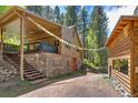 Exterior view of the house with a wood exterior and stone foundation at 7364 Rossman Gulch Rd, Morrison, CO 80465