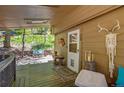 Inviting covered porch with wood decking, outdoor seating, and charming decorative touches at 7364 Rossman Gulch Rd, Morrison, CO 80465