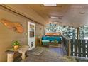 Relaxing covered porch with comfortable outdoor furniture and a view of the wooded landscape at 7364 Rossman Gulch Rd, Morrison, CO 80465
