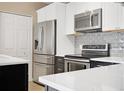 Close-up of the well-equipped kitchen with stainless steel appliances and tiled backsplash at 15475 Andrews Dr # 314, Denver, CO 80239