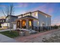 A beautiful two-story home featuring stone accents, warm exterior lighting, and a well-maintained yard at 11582 Jimenez St, Parker, CO 80134